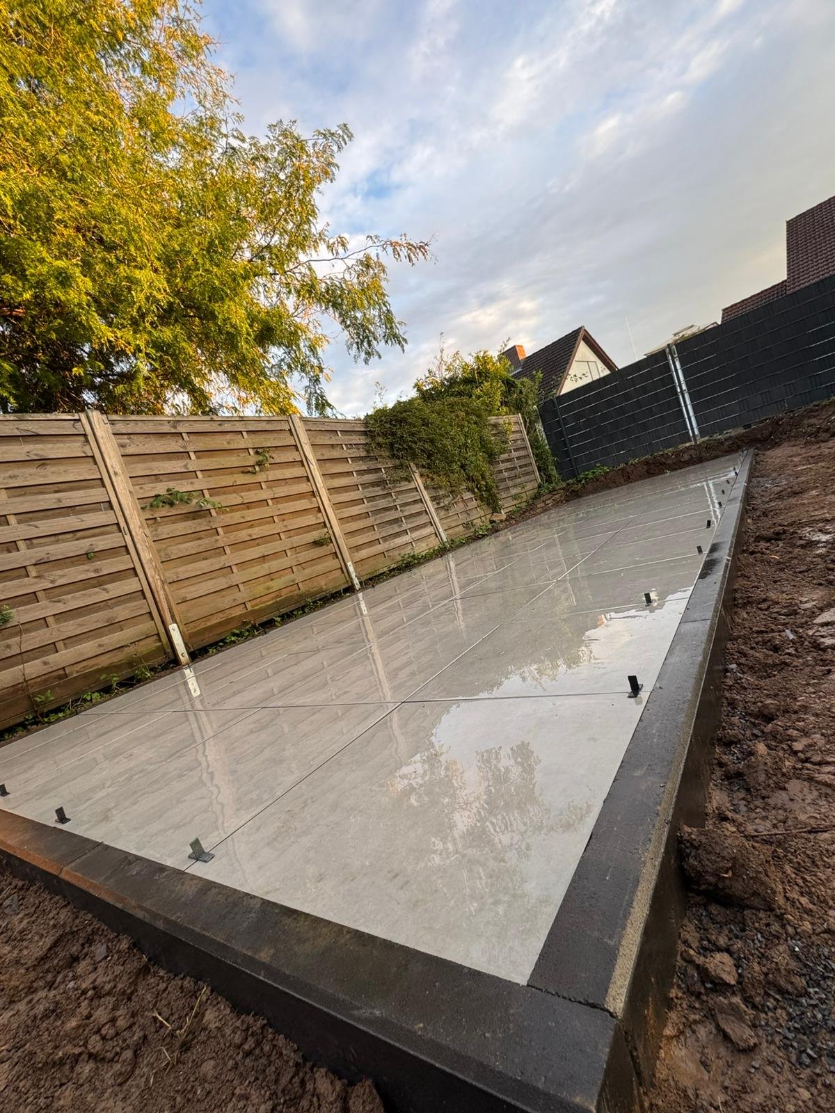 Frisch verlegte Terrassenplatten mit Holzsichtschutz im Garten – Molle GalaBau Brackenheim