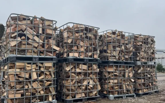 Mehrere mit trockenem, gespaltenem Brennholz gefüllte Gitterboxen auf Holzstapelplatz im Zabergäu